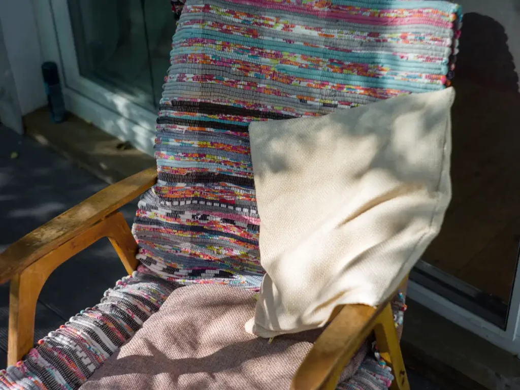 Layer blankets, throws, and cushions made from weather-resistant materials to create a snug and warm patio atmosphere. 